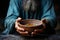 Selective focus on hands and bowl highlights the poignant reality of hunger