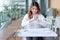 Selective focus on hands of young Asian employee holding crumpled paper and feeling stress against her job in office.