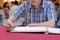 Selective focus on hands of young guest man writing on memory book for blessing word to groom and bride in wedding ceremony