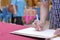 Selective focus on hands of young guest man writing on memory book for blessing word to groom and bride in wedding ceremony