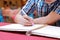 Selective focus on hands of young guest man writing on memory book for blessing word to newlyweds couple in wedding ceremony