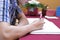 Selective focus on hands of young guest man writing on memory book for blessing word to newlyweds couple in wedding ceremony