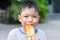 Selective focus. Happy Asian child boy eating an pink vanilla ice cream. Summer season, Delicious feeling, childhood sloppy face