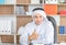 Selective focus of Happy young business arab middle eastern muslim man in office and showing thumb up