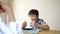 Selective focus Healthy kid having breakfast with parent.Asian mother and mixed race son eating food in the morning,Family spend t