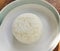 With selective focus on Hot steamed rice is placed in a white plate on wooden table in restaurant. For serving to customers