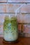 Selective focus of iced green tea in glass on wooden table