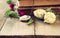 Selective focus image of dry rose, antique necklace and old vintage books on wooden table. retro filtered image