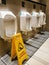Selective focus image with noise effect cleaning in progress sign in public toilet.
