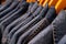 Selective focus on jacket jeans hanging on rack in clothes shop. Denim jeans with jeans pattern. Textile industry. Jeans fashion