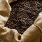 Selective focus on jute bag full of fresh roasted arabian coffee beans