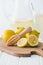 selective focus of lemons and wooden squeezer on cutting board for making fresh lemonade on white
