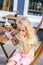 selective focus of little child licking fingers while sitting at table with delicious dessert