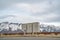 Selective focus mailboxes beside a road against snowy mountain and cloudy sky