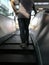 Selective focus at male backside, man stand on escalator