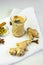 selective focus, masala tea on white background with cinnamon and ginger spices