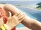 Selective focus of Middle age hand with sun cream on her shoulder with  sunscreen  on the poolside as applying moisturizing lotion