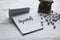 Selective focus of miniature typewriter,alphabet beads and notebook written with Keywords on white wooden background