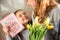 selective focus of mother and daughter holding yellow tulips and happy mothers day