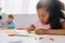 selective focus of multicultural preschoolers drawing pictures with pencils