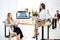 selective focus of multiethnic businesswomen at workplace with financial protection inscription on screen and colleagues behind