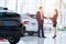 Selective focus on a new car and blur the dealership professional salesman and his client shaking hands. concept professionalism