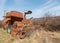 Selective focus on old abandoned combine harvester for grain crops in the field. Broken rusty equipment