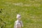 Selective focus on a old weathered limestone figure of a woman in the garden in front of a blurred meadow with daisie at a sunny