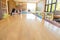 Selective focus with perspective view of long wooden table with colorful chairs and blurred asian kid girl and mother using laptop