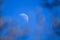Selective focus photo. Growing moon in the blue sky.