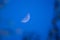 Selective focus photo. Growing moon in the blue sky.