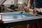 Selective focus photo of male hands with squeegee. serigraphy production. printing images on t-shirts by silkscreen method in a