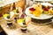 Selective focus photo of Seasonal Tropical Fruit creamy trifle in beautiful glasses with fresh ripe fruit slice, table background