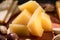 Selective focus of pieces of grana padano with olives, slices of pear and pistachios on wooden background.