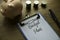 Selective focus of piggy bank,stack of coins,pen and clipboard with paper written with Budget Plan on wooden background