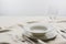 Selective focus of plates and wine glass on tablecloth on grey background