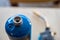 Selective focus on propane gas canister with blurred nozzle and head of blowtorch in the background