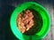 Selective Focus of Raw Chicken Meat in a Green Plastic Container Under Bright Sunlight