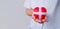 Selective focus of red heart wrapped by white plus sign bandages as a gift. The heart holded by doctor with blurred effect with