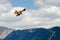 Selective focus of a red kite hunting in the air under a blue cloudy sky in the countryside