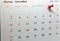 Selective focus of a red push pin marking on calendar date