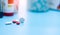 Selective focus on round white and red tablets pills on blur plastic drug bottle. Pharmacy drugstore products. Pharmaceutical