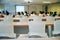 Selective focus on row of empty chairs with blurred group of students in background