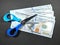 Selective focus.Scissors and money on a black background.Salary cut cost concept.