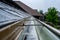 Selective focus on a section of residential guttering with hanger conveying water during a storm. Rain splatters and