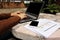 Selective focus and shallow depth of field of hands of business person is typing a laptop with blank screen , charts and mobile ph