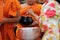 Selective focus and shallow depth of field, Hands of Thai people put food offering in Buddhist monk`s alms bowl in Visakha Puja Da