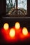 Selective focus shot of advent wreath with burning red candles and candle arch in window