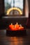 Selective focus shot of advent wreath with burning red candles and candle arch in window