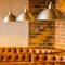 Selective focus shot of brown leather restaurant sofa with hanging stainless steel ceiling lamps